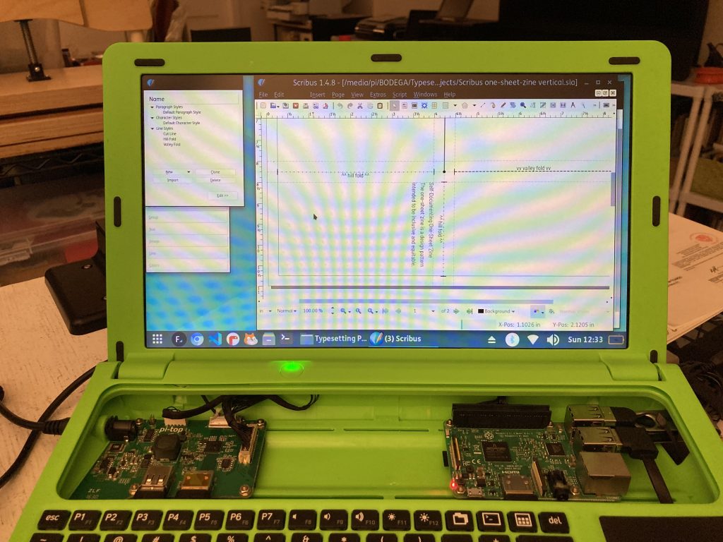 photo of the screen of a Pi-Top[1] with the Raspberry Pi 3B+ exposed. On the screen is the page layout programm Scribus with a closeup of an early draft of the one-sheet 'zine mentioned in this post